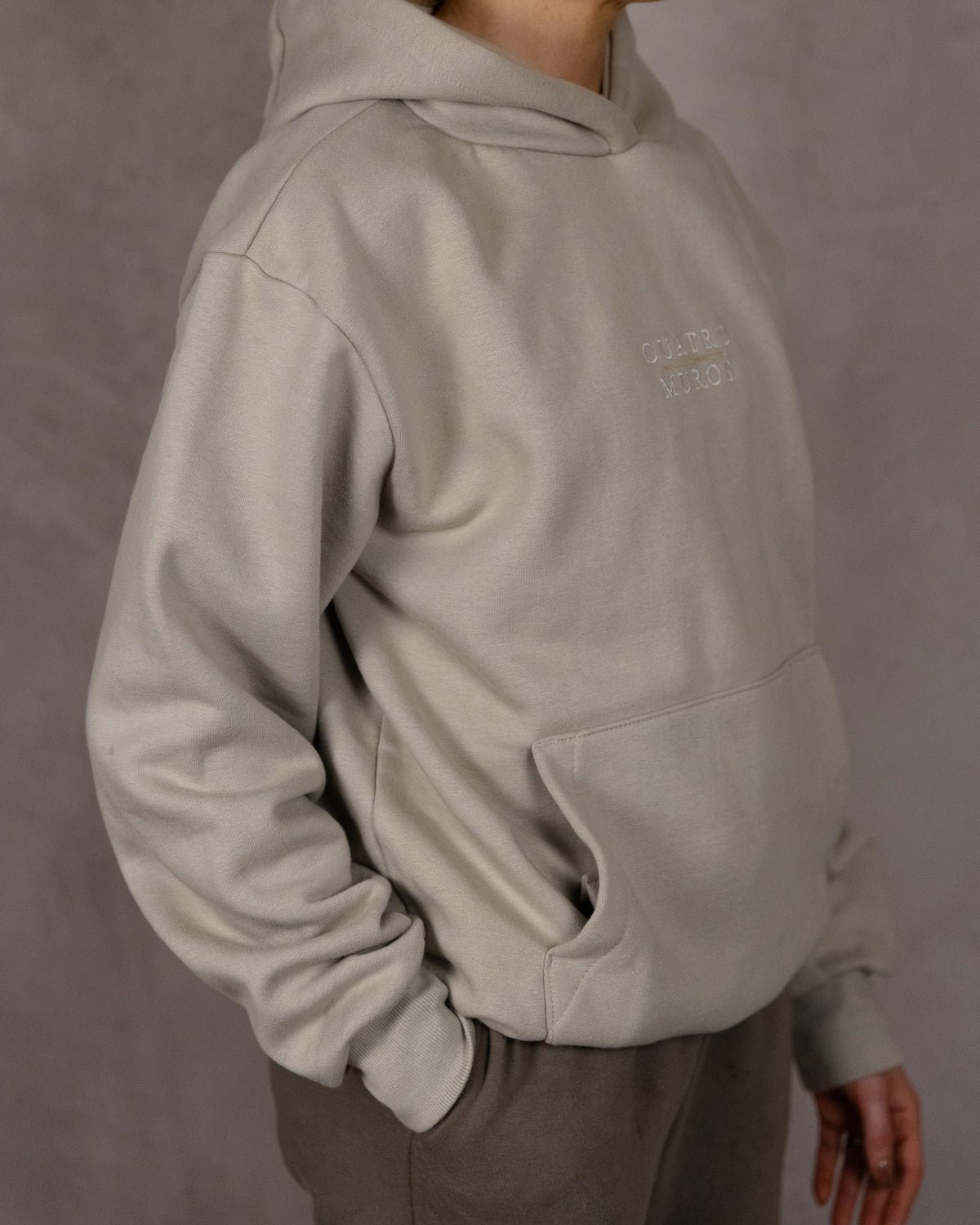 The Malla Hoodie in Natural Stone, side, worn by a 5ft 6 model in size Small