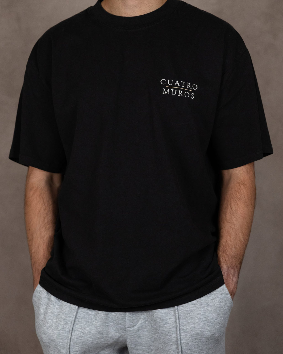 The Muro Tee in Faded Black, front, worn by a 6ft model in size Large