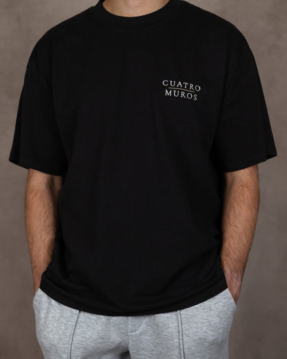 The Muro Tee in Faded Black, front, worn by a 6ft model in size Large