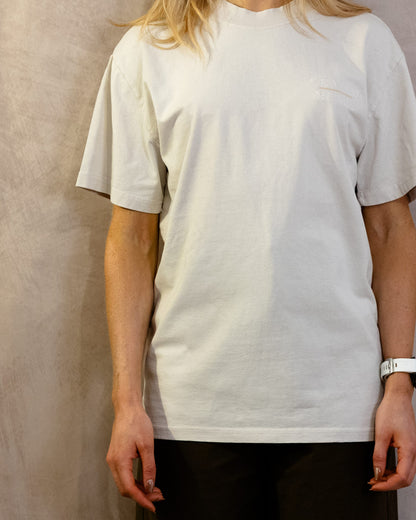 The Muro Tee in Faded Bone, front, worn by a 5ft 6 model in size Small