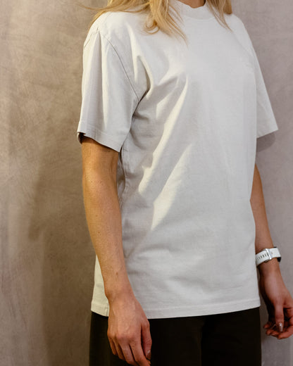 The Muro Tee in Faded Bone, three-quarter front, worn by a 5ft 6 model in size Small