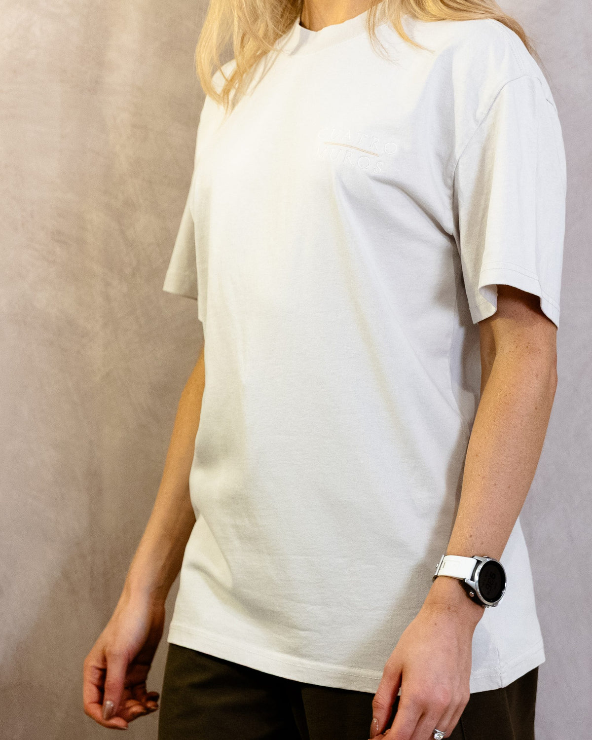 The Muro Tee in Faded Bone, front with a slight turn, worn by a 5ft 6 model in size Small