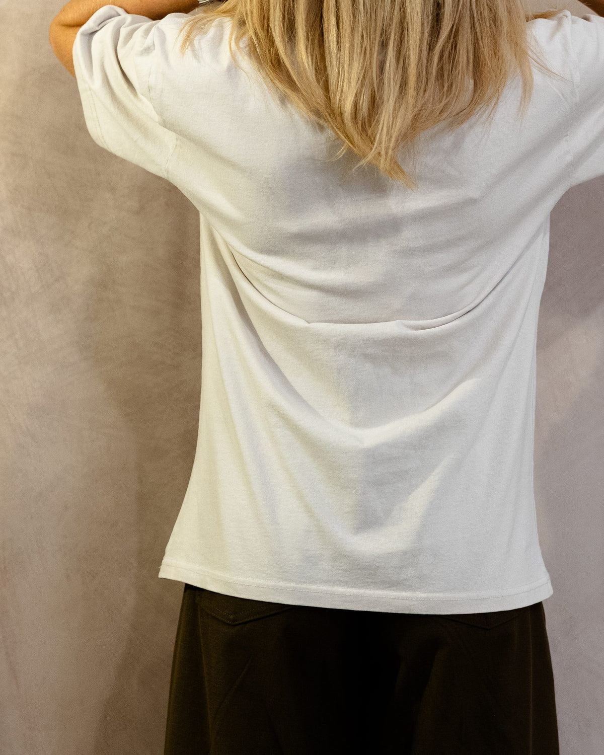 The Muro Tee in Faded Bone, back, worn by a 5ft 6 model in size Small