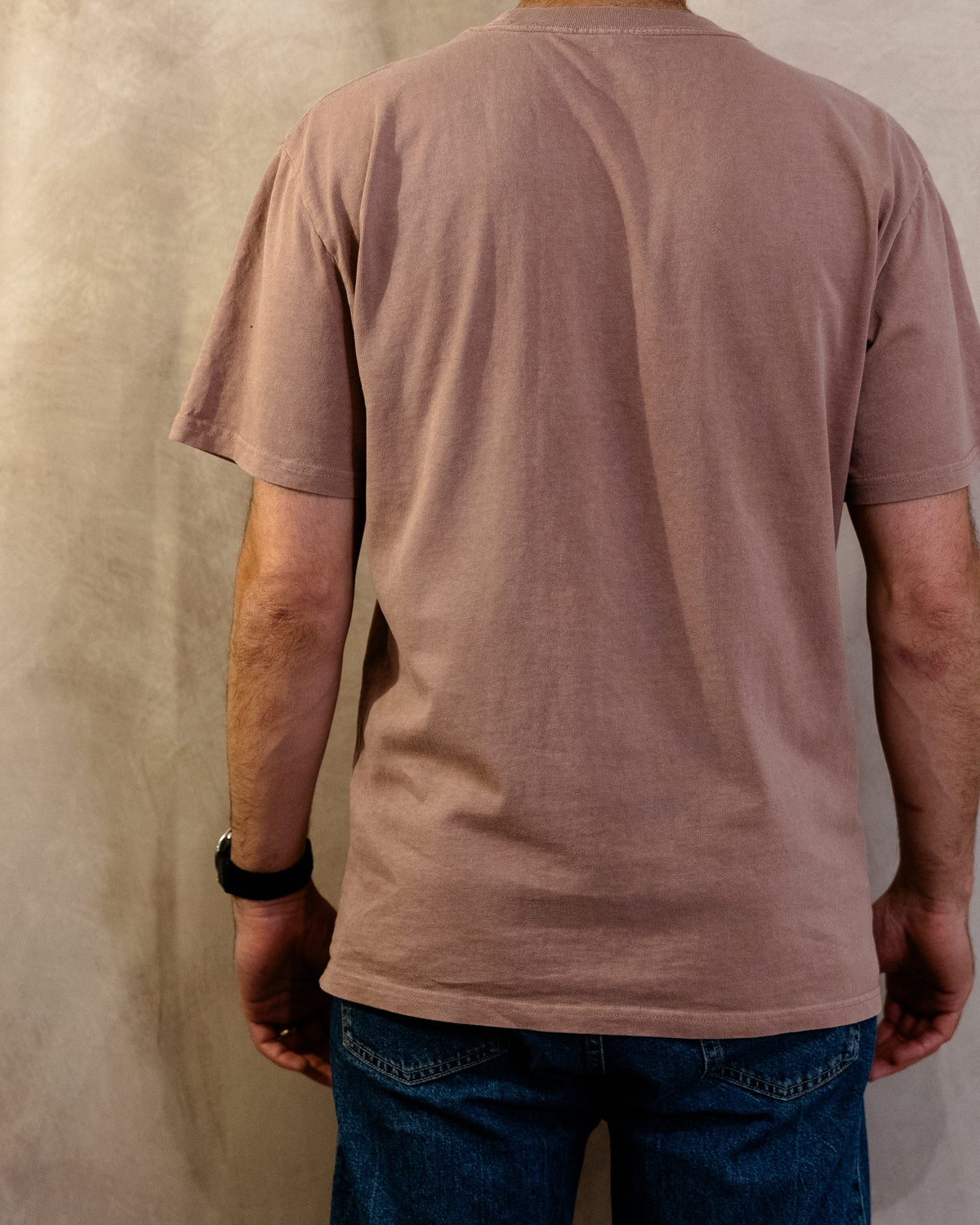 The Muro Tee in Faded Pink, back, worn by a 6ft model in size Large